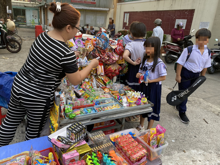 Trước cổng Trường tiểu học Bình Trị 1 (quận Bình Tân), sạp hàng rong bày bán đủ các loại bánh kẹo không rõ nguồn gốc, có ghi chữ Trung Quốc trên bao bì - Ảnh: VŨ HIÊN