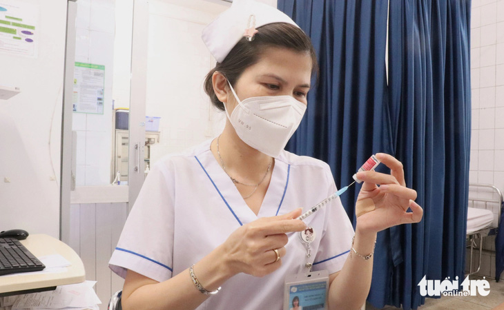 Nhân viên y tế Bệnh viện Bệnh nhiệt đới (TP.HCM) chuẩn bị vắc xin phòng bệnh dại tiêm cho người dân bị chó cắn - Ảnh: XUÂN MAI